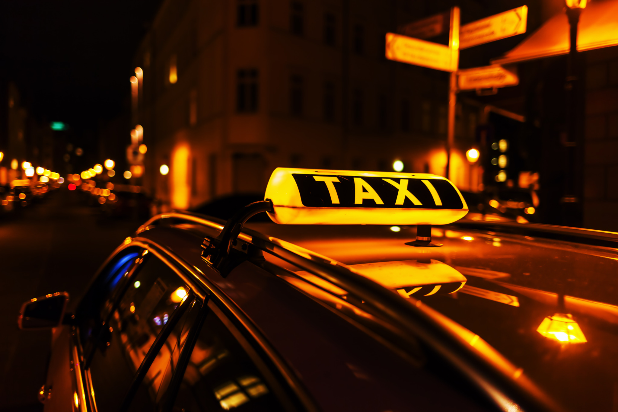 taxi sign on the roof of a taxi at night